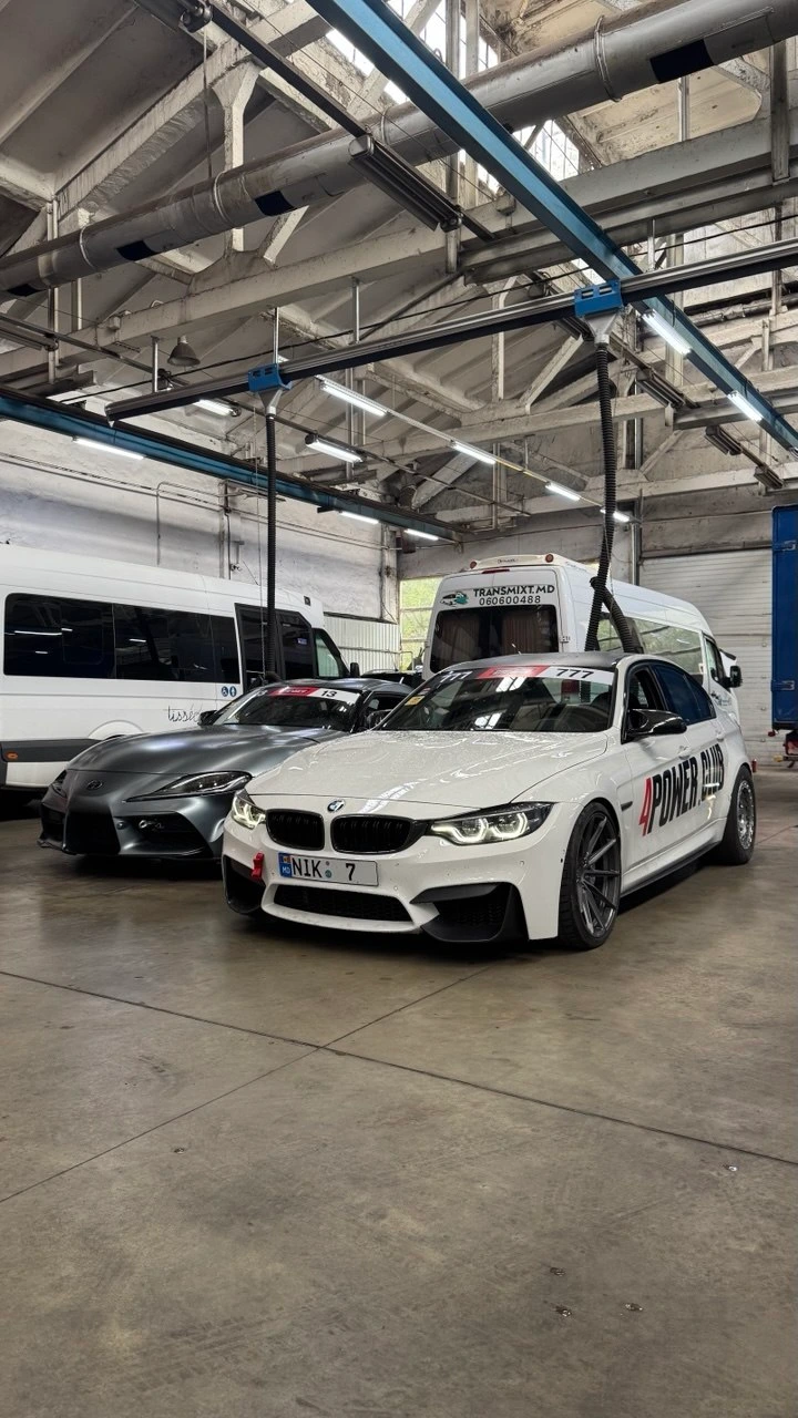 BMW M3 F80 albă a lui Nikita, cu numărul NIK 7, și o Toyota Supra în atelier